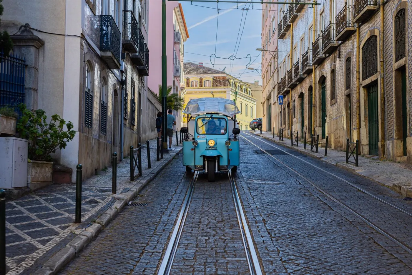 A Chico Chico tuk tuk in a narrow Lisbon street
